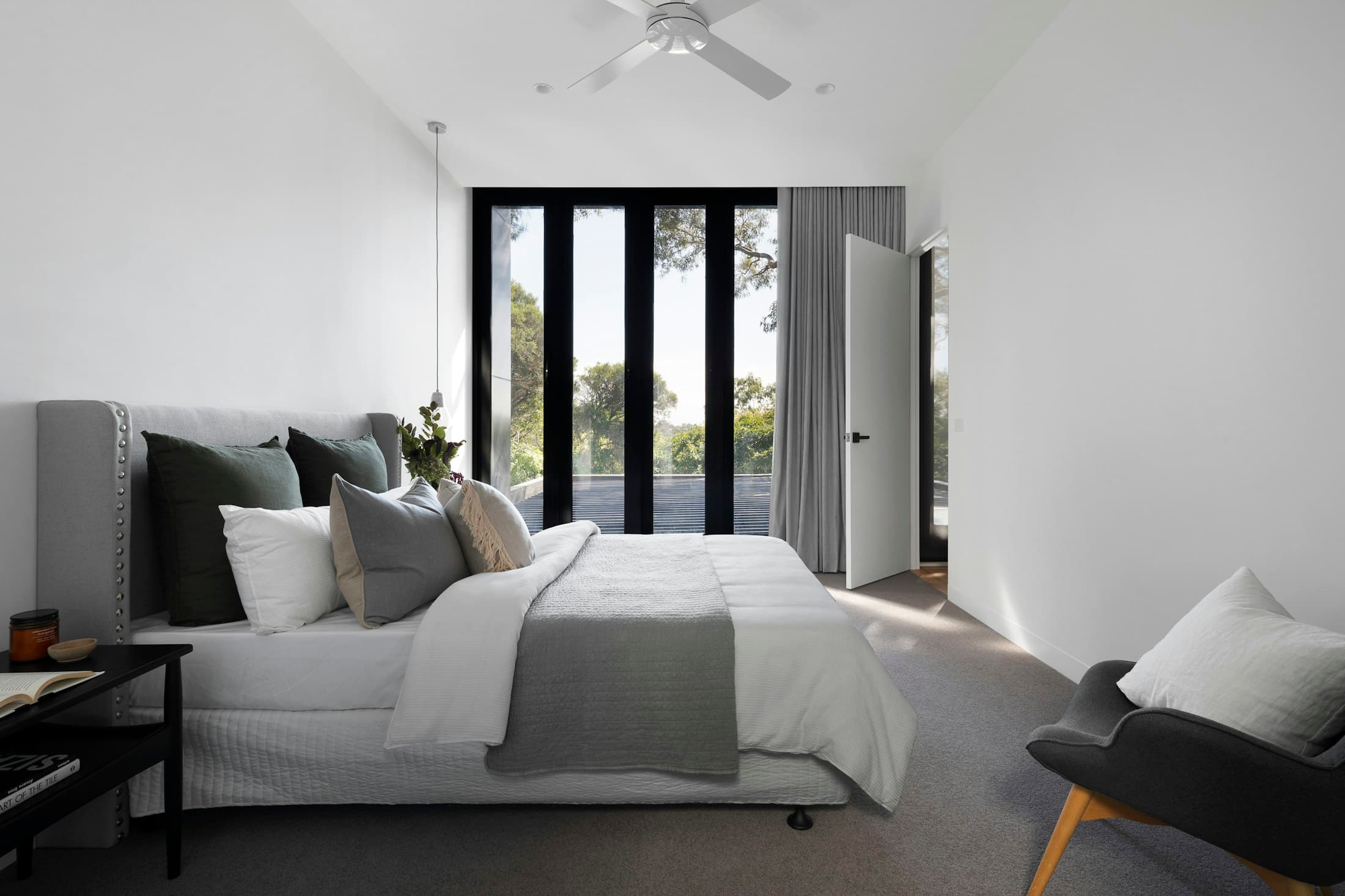 Calm, light bedroom with floor-to-ceiling windows